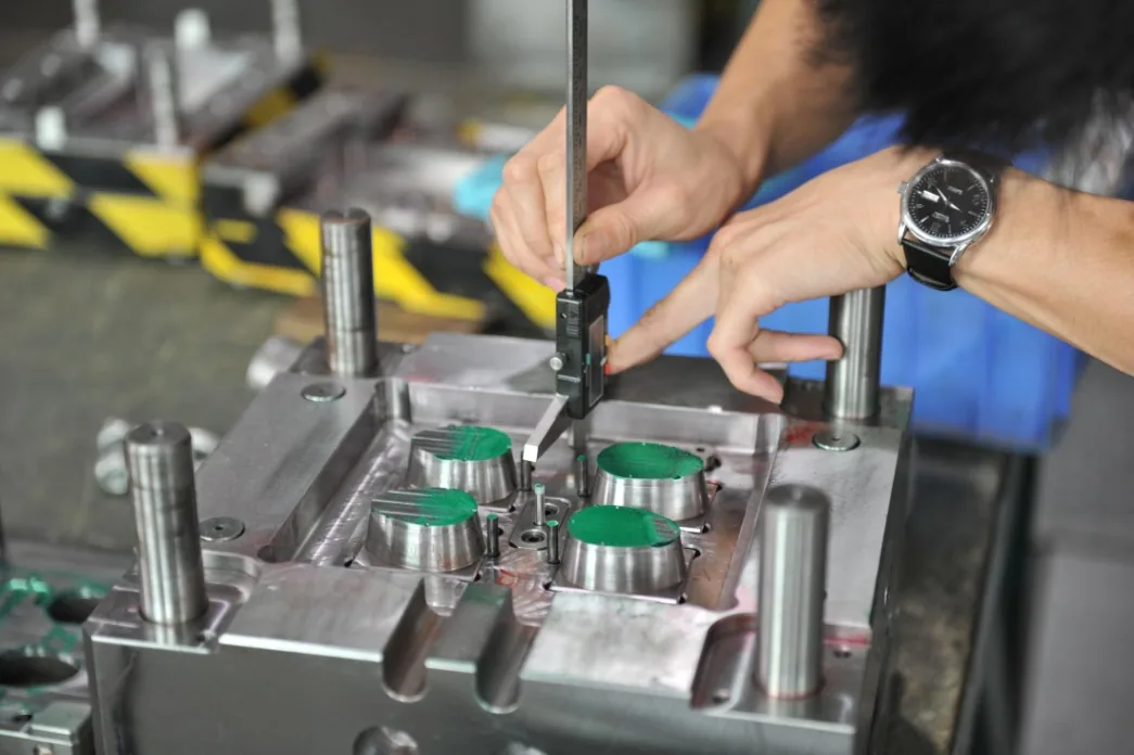 Technician fitting and checking an automotive injection mold
